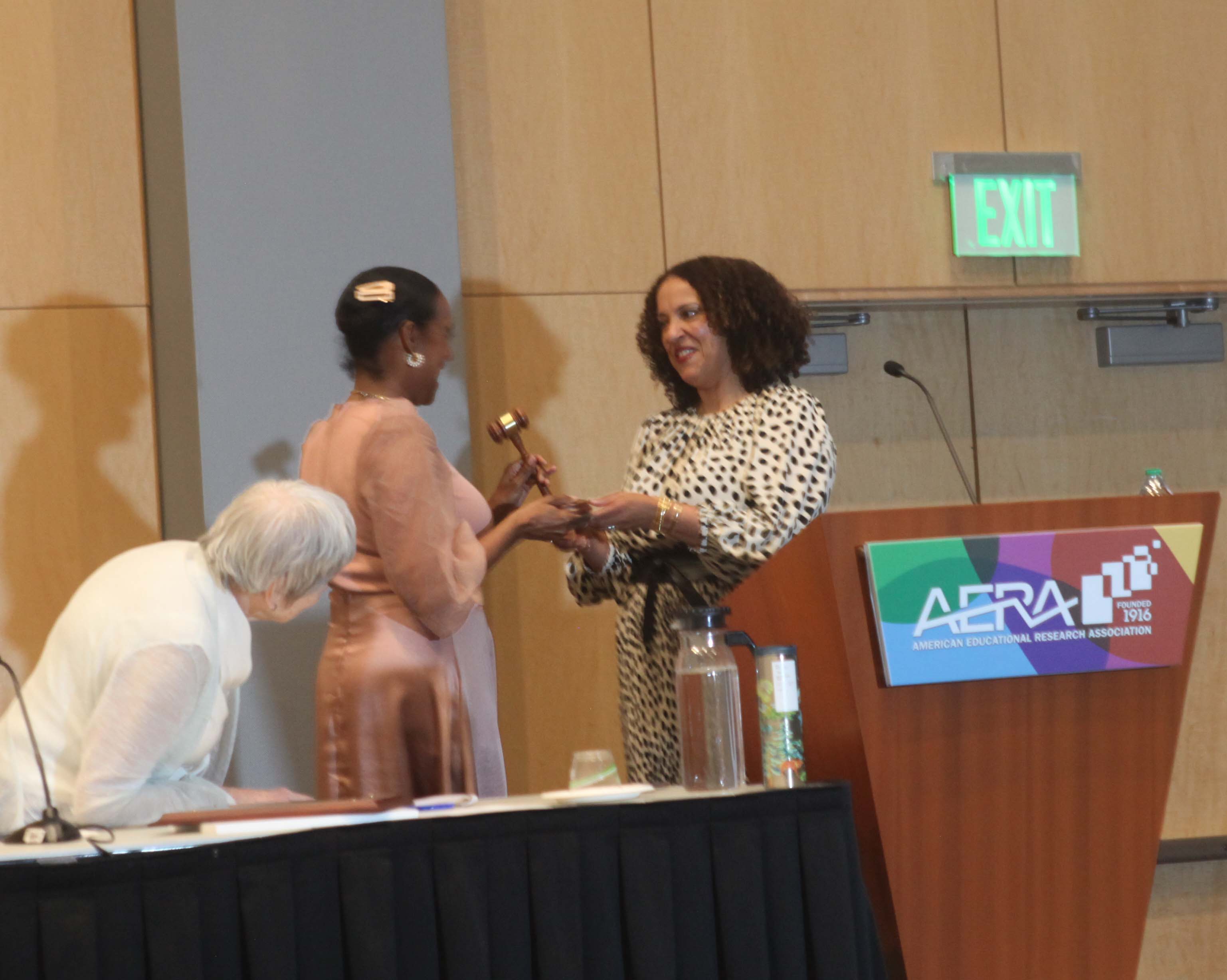 Maisha T Winn receives the ceremonial gavel from Janelle Scott