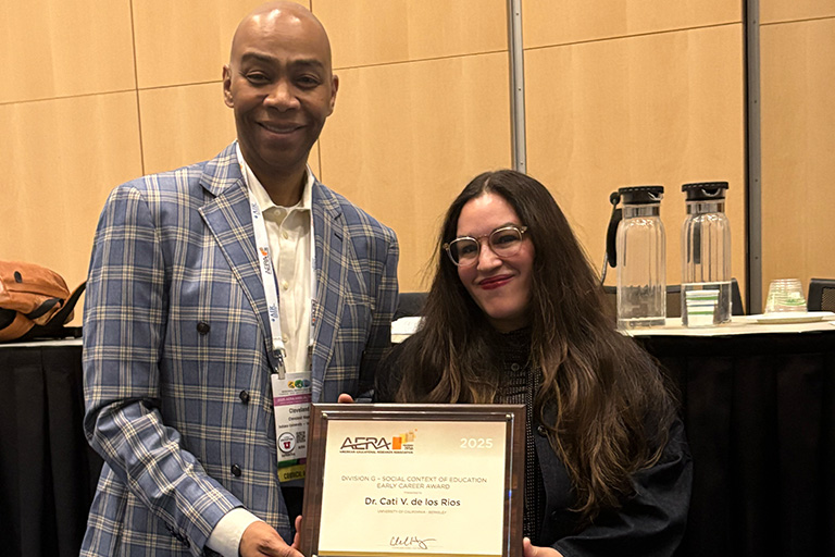 cati v de los rios stands with her division g award and is next to division vice president cleveland hayes