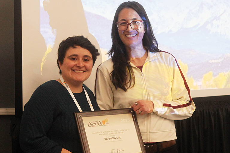 yared portillo holding the award standing next to Michiko Hikida who presented the award and both are smiling at the camera