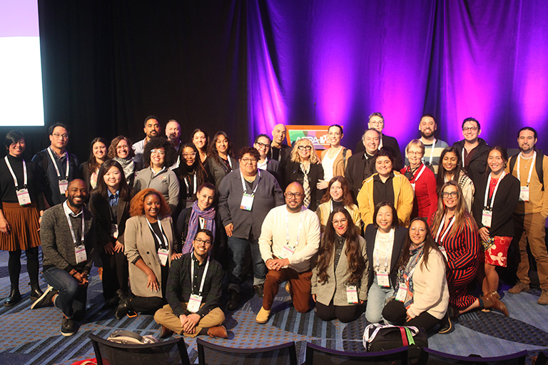 group picture with 35 people and everyone smiling at the camera and professor kris gutierrez is in the center