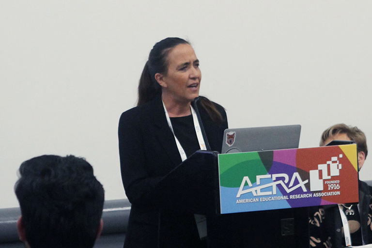 Özge Hacıfazlıoğlu standing at podium presenting research