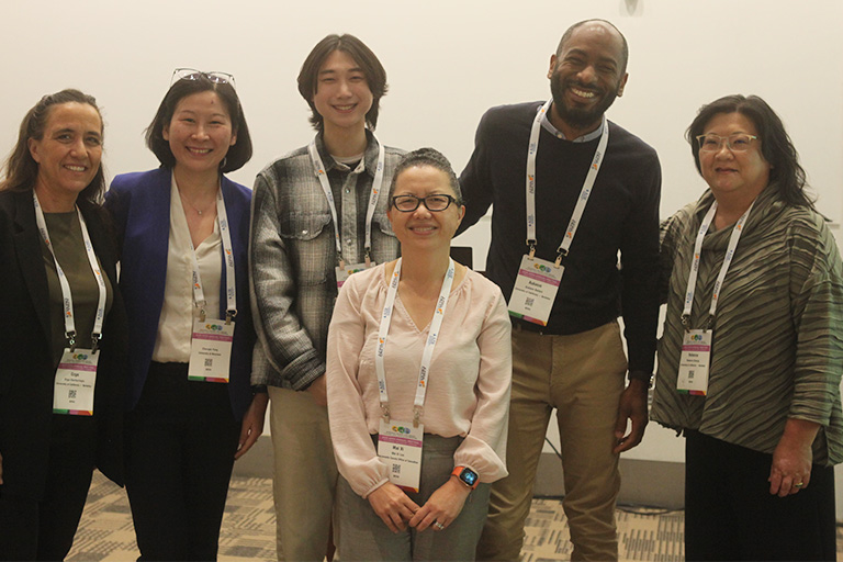 six people who presented at the session standing next to each other smiling at the camera