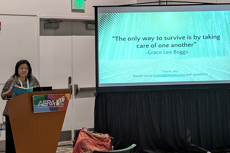 Rebecca Cheung at podium speaking as a discussant in the session