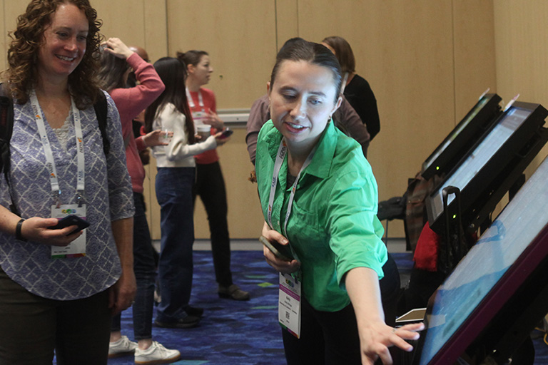 doctoral student kelly billings pointing to her poster as she discusses findings