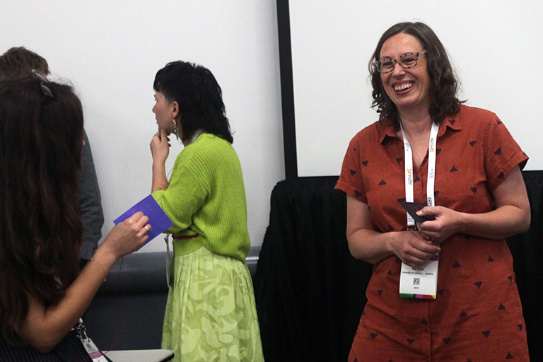doctoral student meg escude standing and discussing research findings