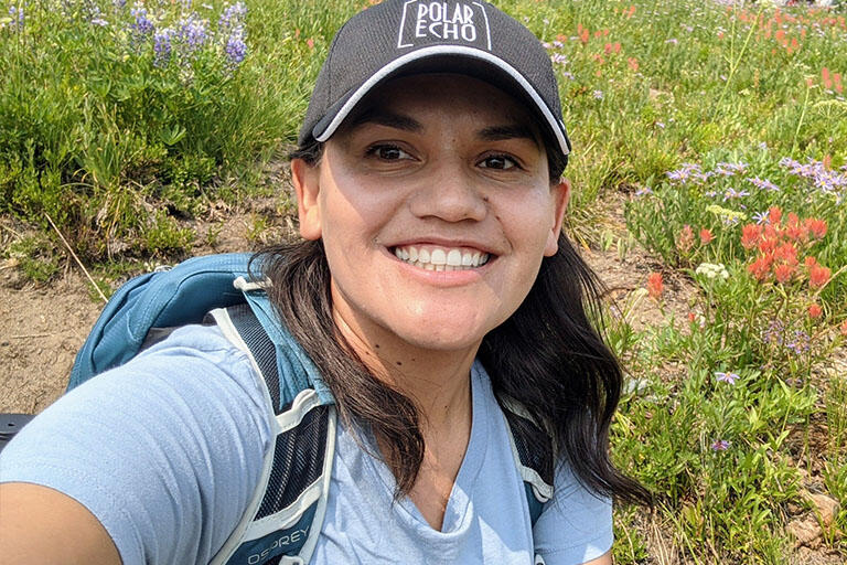 portrait of doctoral candidate arlyn moreno luna with wildflowers in the background