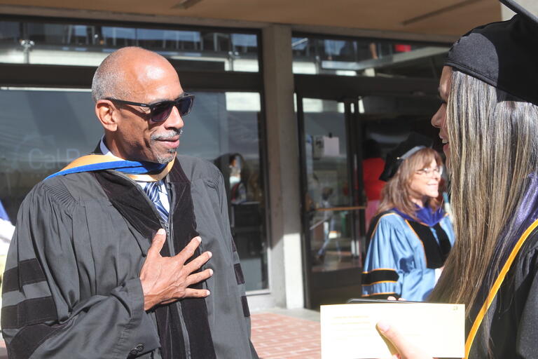 Dr, Noguera and graduate at commencement outside 
