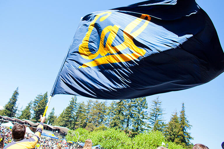large flag with word cal on in waving in the wind