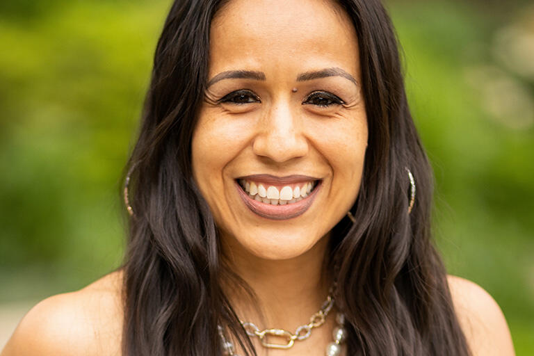 Professor gina garcia smiling at camera wearing white tank top dress double necklace of pears and small silver chain