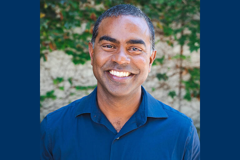 Professor thomas philip smiling at camera wearing dark blue button up shirt