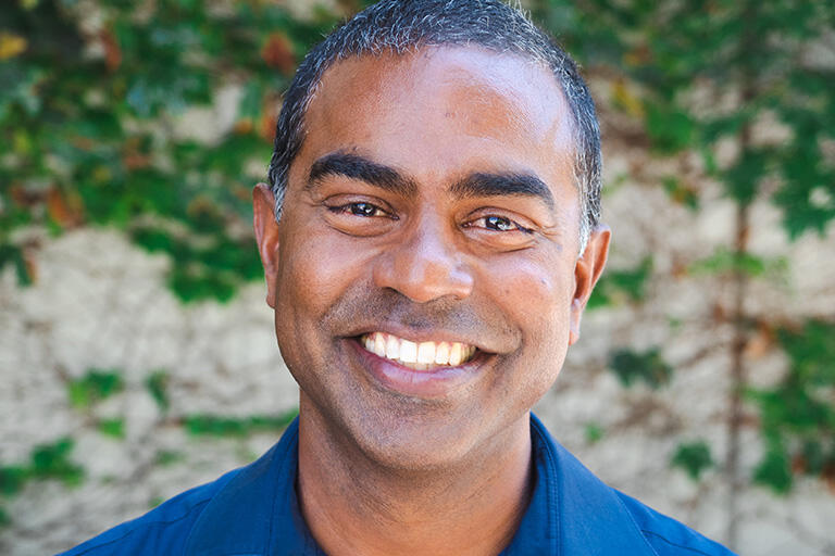 professor thomas philip smiling at camera wearing blue button up shirt