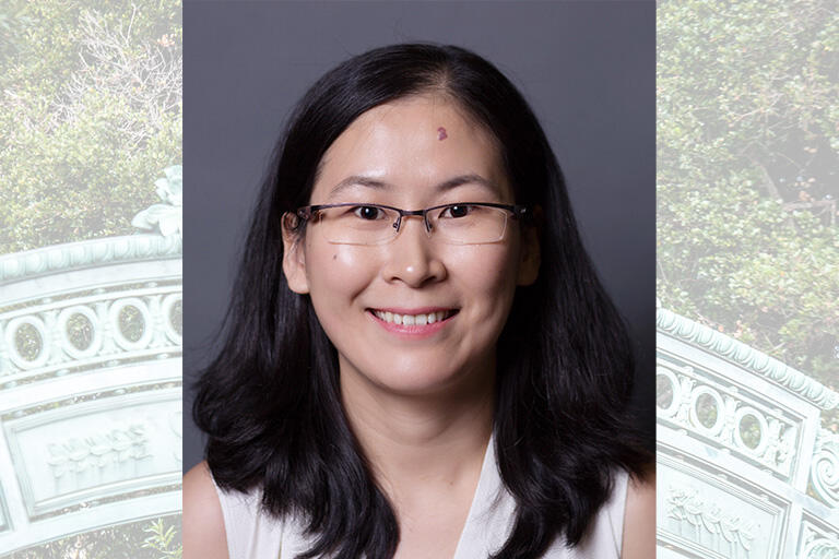 professor chunyan yang wearing white v necked sleeveless blouse smiling at camera