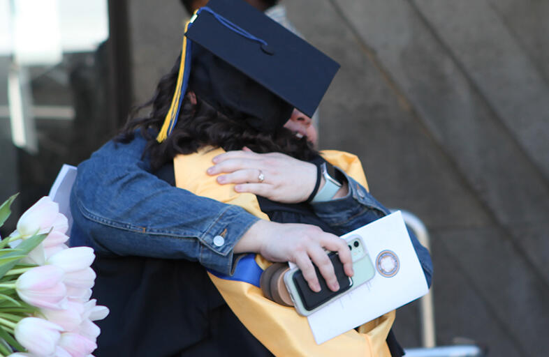 graduate hugging someone