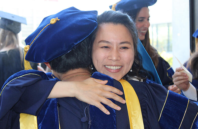 graduate hugging a faculty member