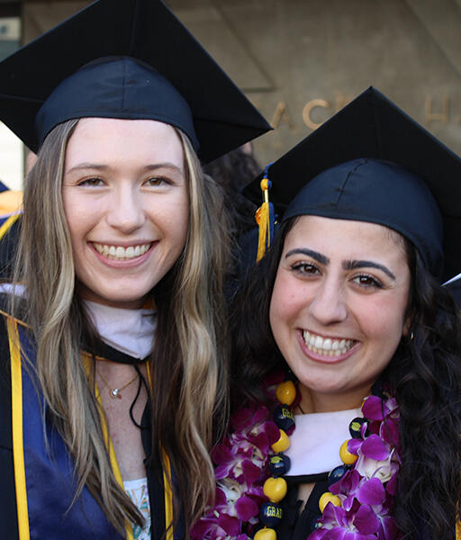 two graduates smiling at camera