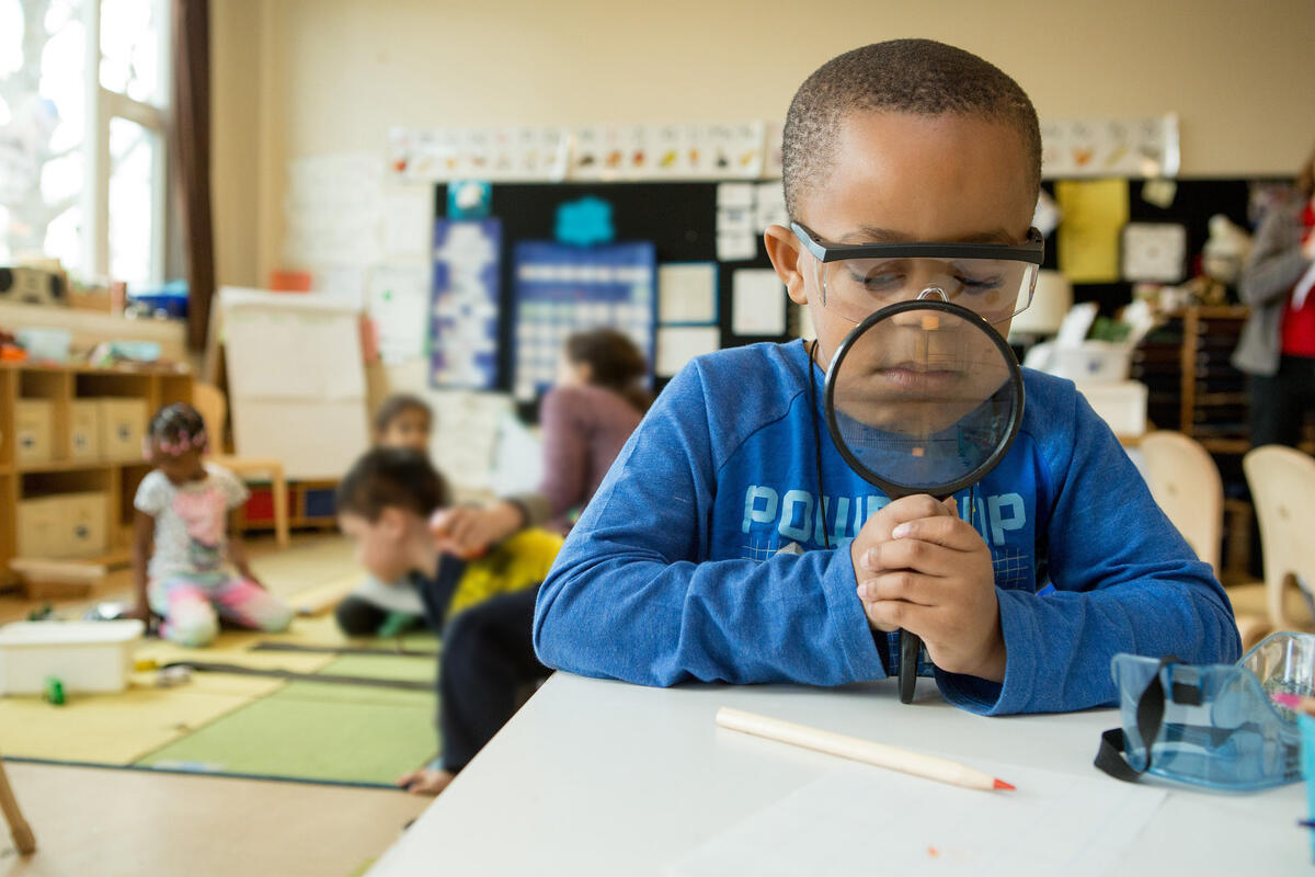 kindergarten boy with magnifying glass