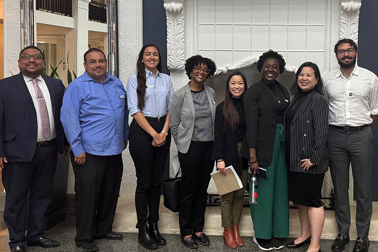 eight people standing next to each other all smiling at the camera