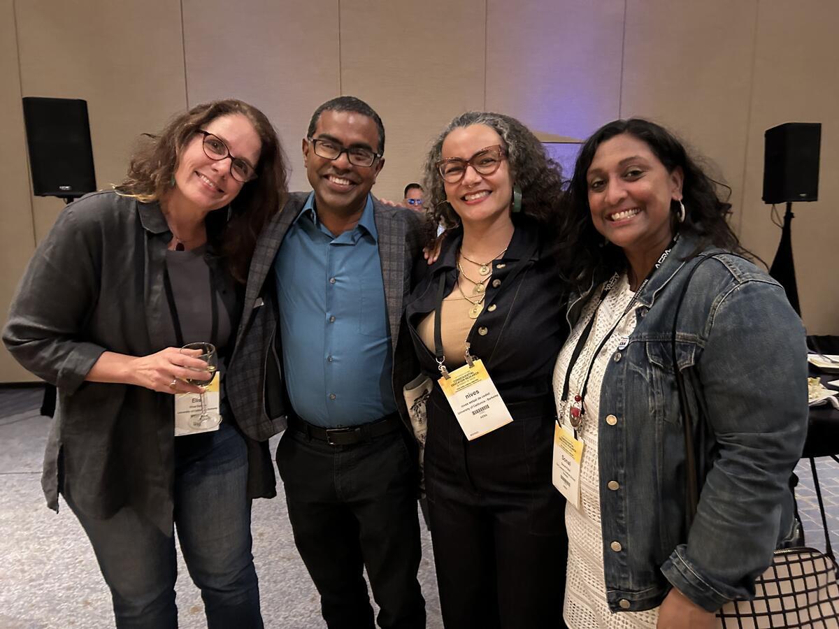 four people from berkeley teacher education program standing next to each other smiling at camera