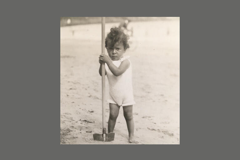 black and white image of guy benveniste as a baby standing on the beach