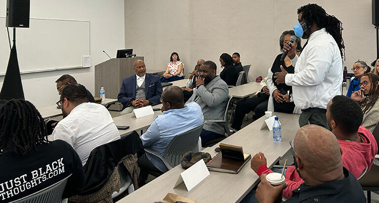 an audience member standing up asking a question of the panelists
