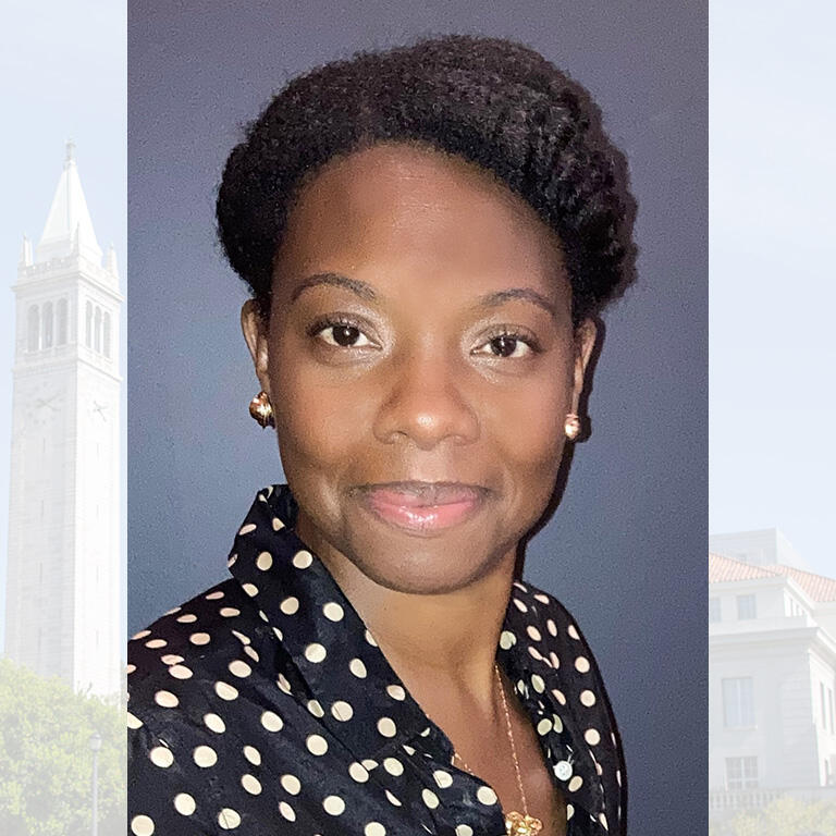 Professor Tolani Britton wearing black blouse with white polka dots smiling at camera