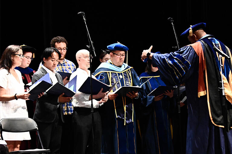 b s e choir performs during the ceremony with professor frank worrell conducting