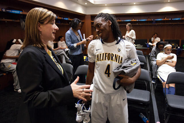teresa gould talking with Cal women's basketball player who is wearing her white uniform number four