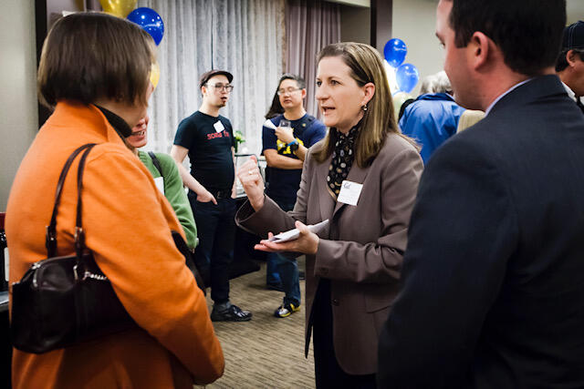 teresa gould talking with two others at a reception