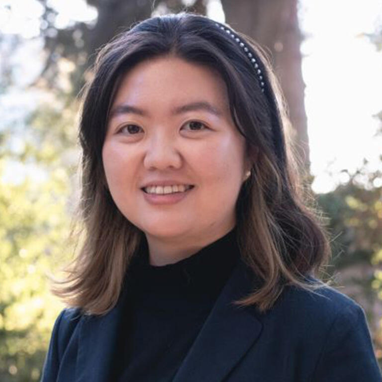 doctoral student hoyun kim smiling at camera wearing black top navy blue coat