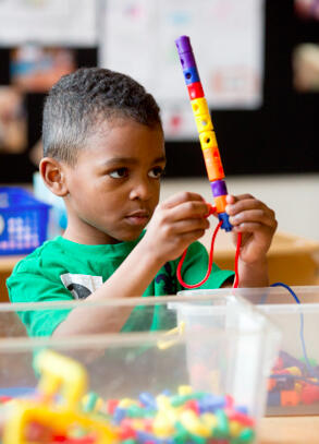 elementary school student playing with colored blocks