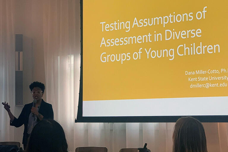 assistant professor dana miller cotto giving a lecture and on screen is title of her talk testing assumptions of assessment in diverse groups of young children