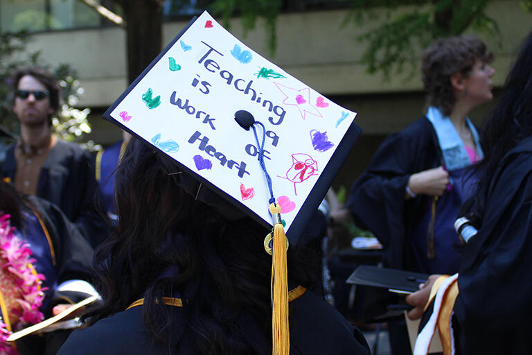 a mortar board decorated with the words teaching is a work of heart with stars and hearts drawn around the edges