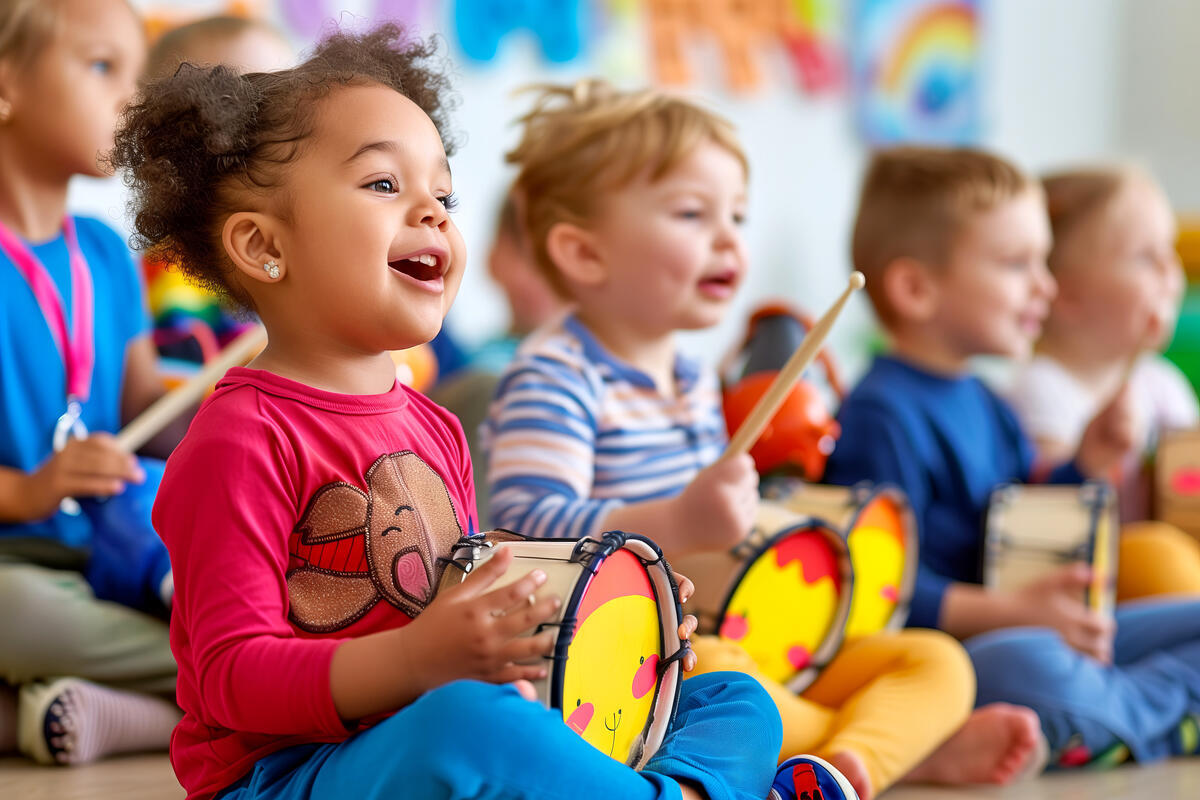 three preschool children playing with drums