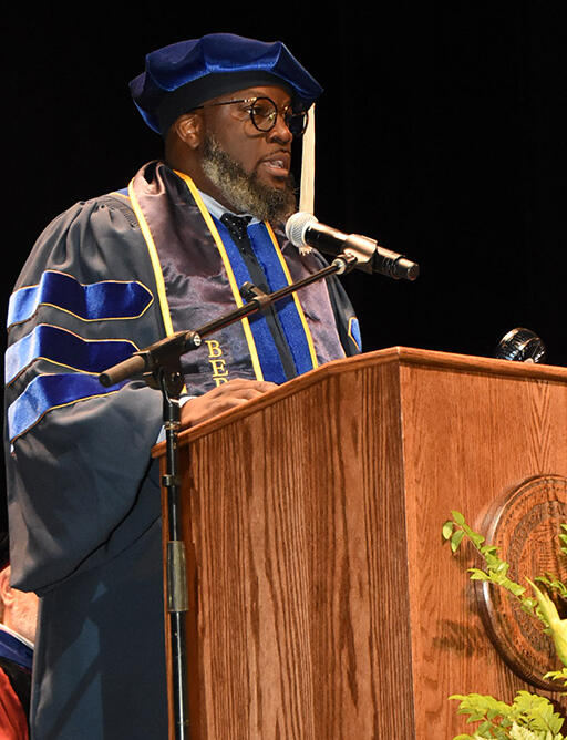 doctoral graduate olufemi ogundele at podium giving speech